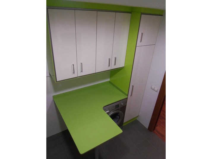 Zona para la colada en verde pistacho y muebles de cocina en blanco brillo