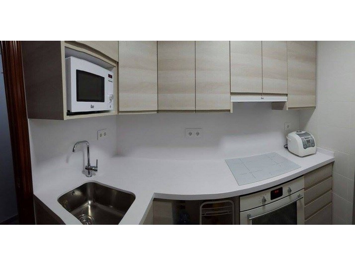 Cocina nórdica uñero con encimera con canto inglete y frontal en Silestone Blanco Zeus.